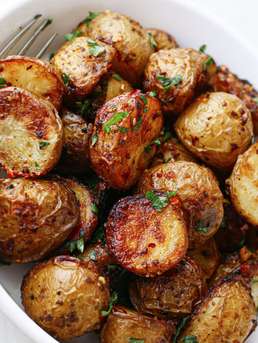 Spicy roasted potatoes in a bowl, close up.