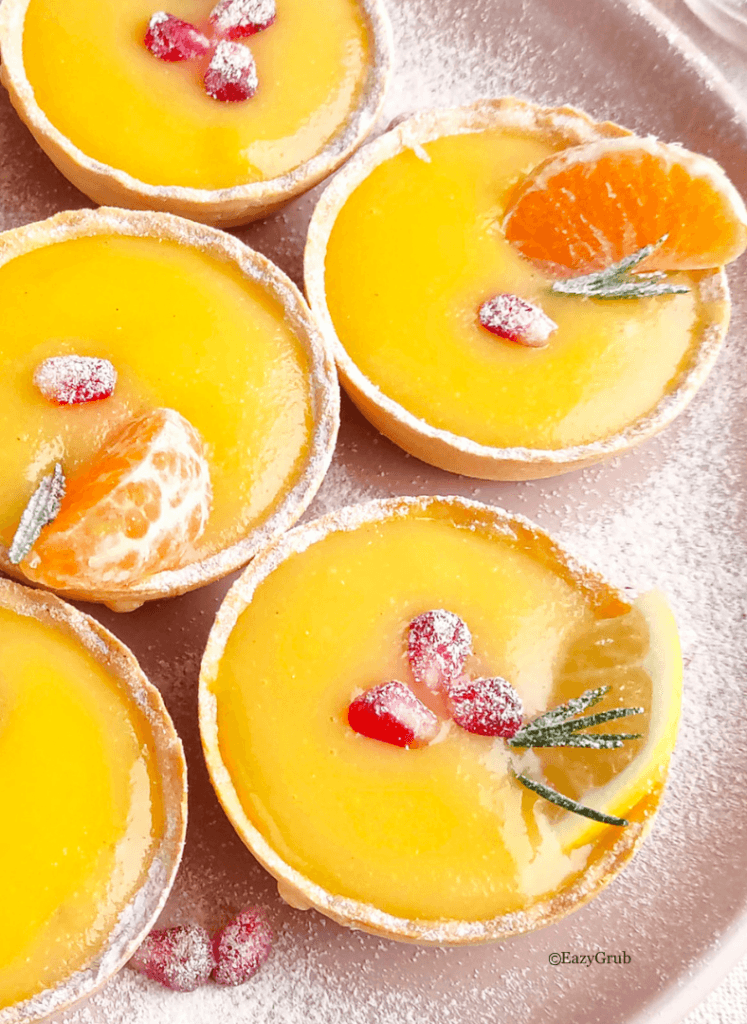 Close-up of lemon curd tart showing creamy citrus filling inside a crisp tart shell.