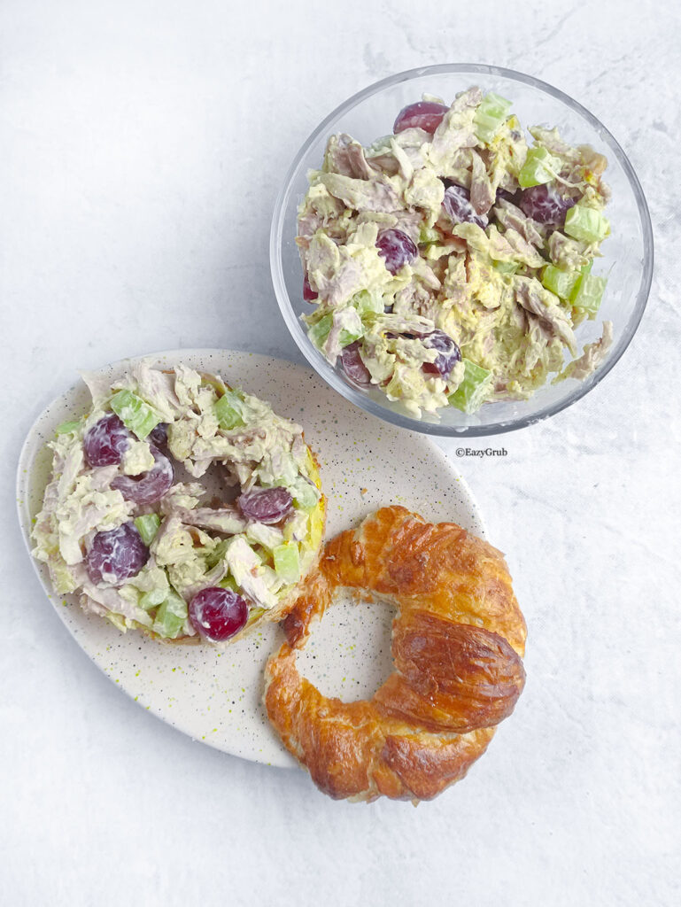 4-ingredient chicken salad in a glass bowl as well as on the bottom part of a croissant.