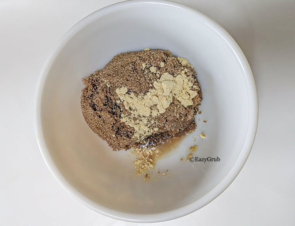 Brown sugar and mustard powder with a touch of apple cider vinegar in a bowl.