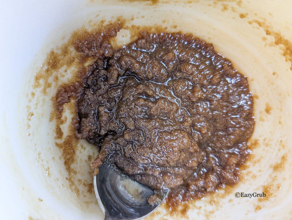 the brown sugar glazed mixed together. There is a spoon in the bottom left of the image.