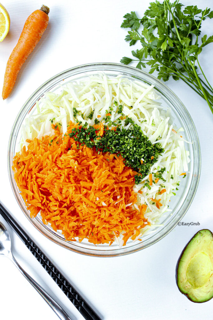 shredded carrots and cabbage with minced parsley in bowl