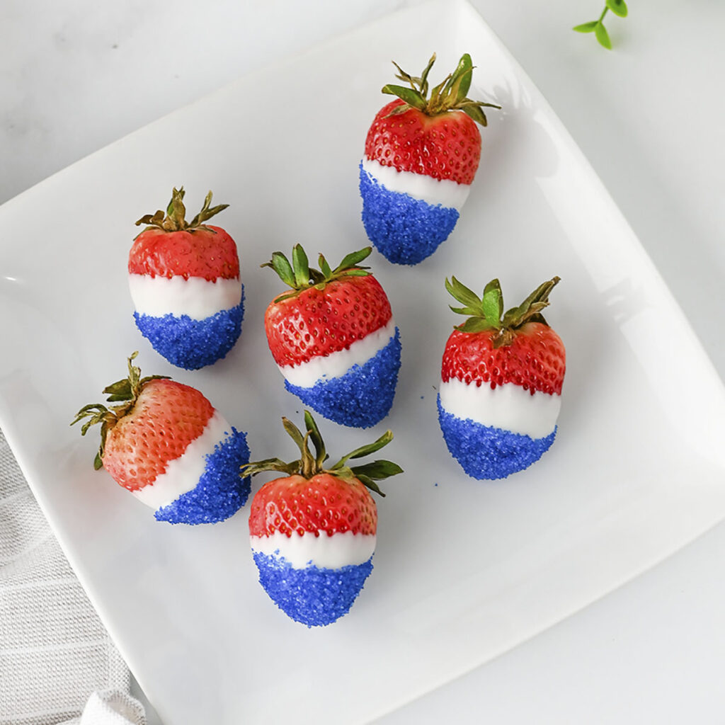 6 strawberries decorated in 4th of july colors.