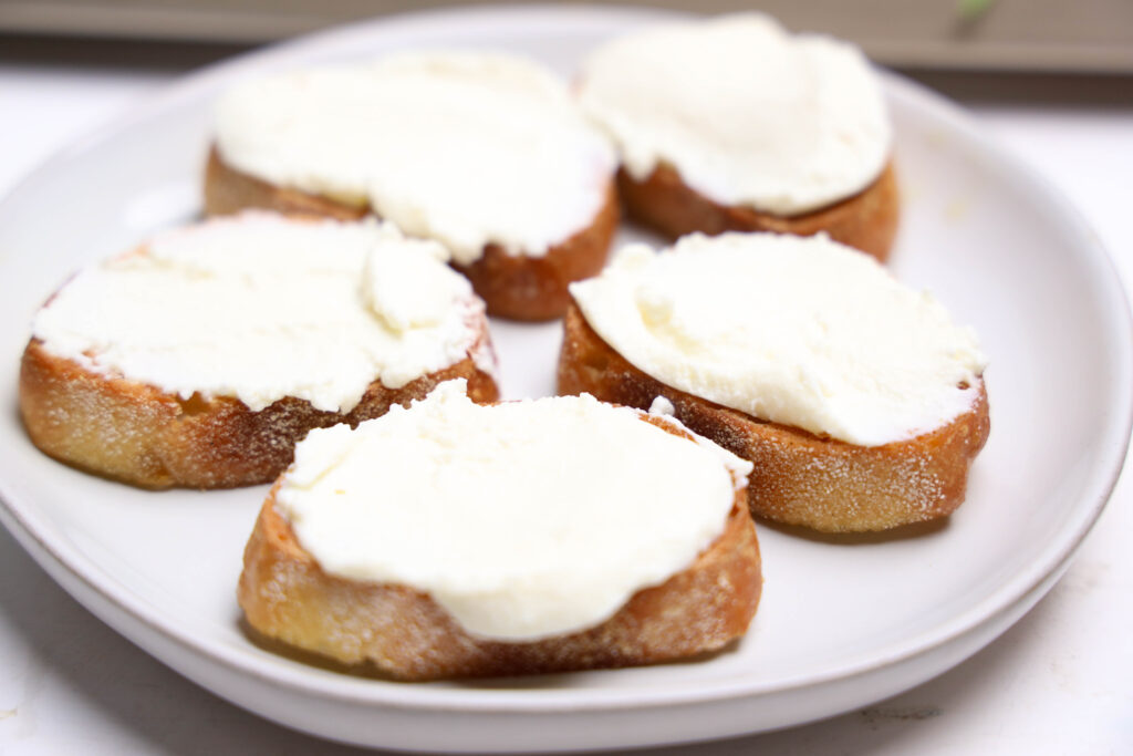 Small toasted bread rounds covered with ricotta cheese