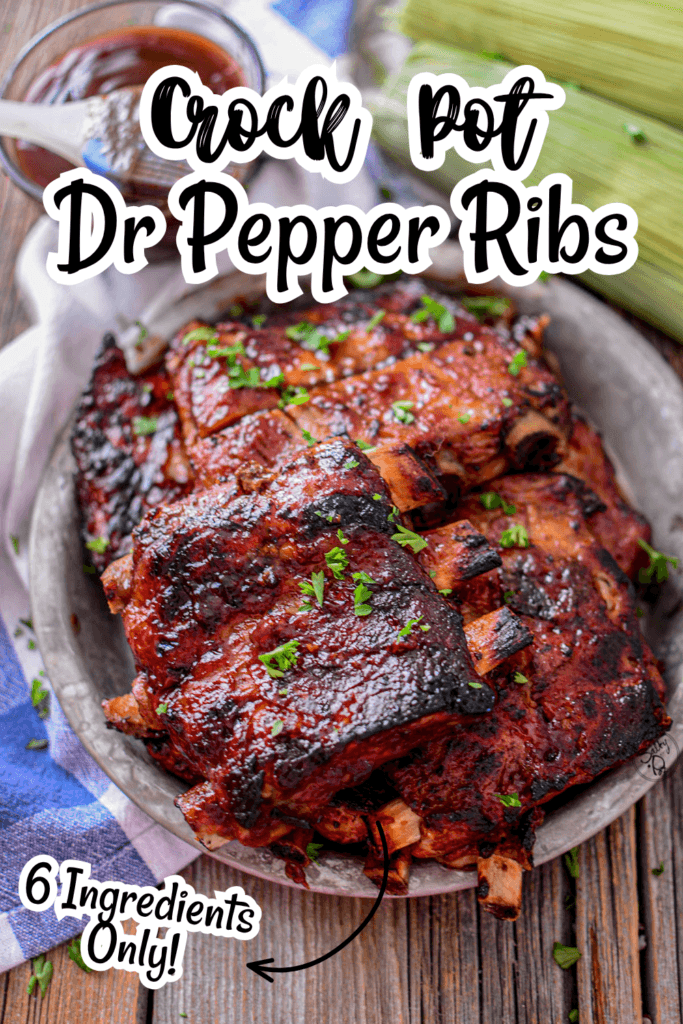 Glazed cooked rib pieces stacked on a dark slate board and garnished with herbs.