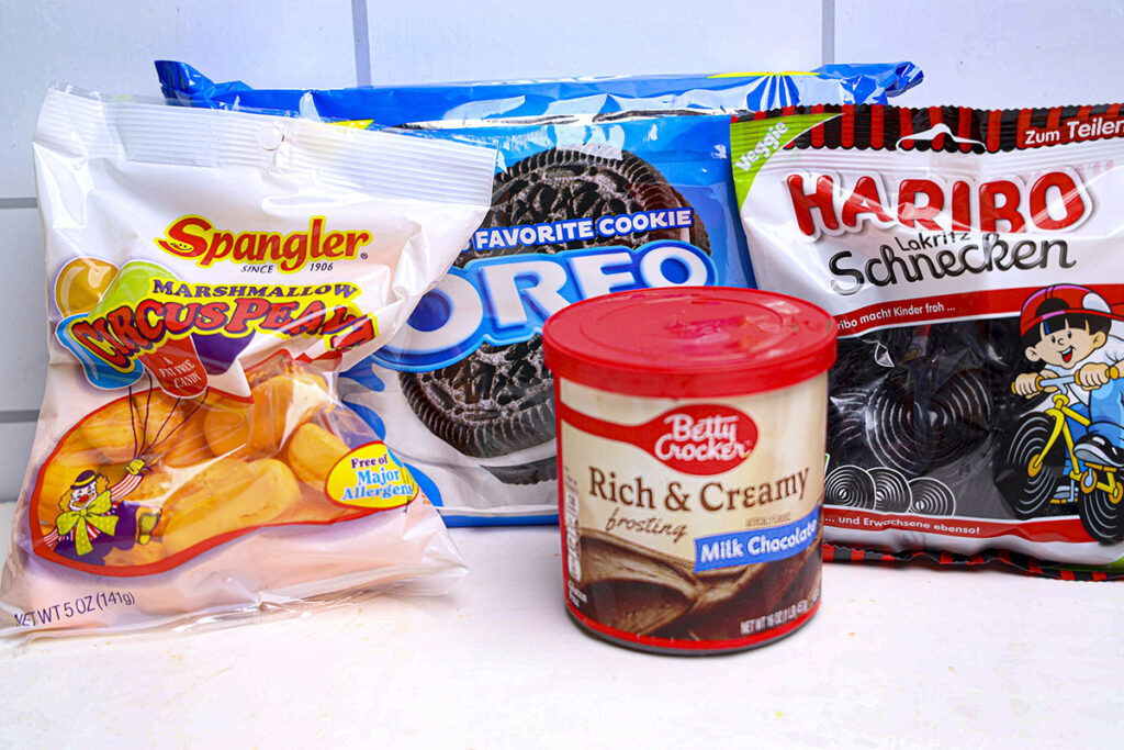 ingredients for the crow oreo cookies. Circus Peanuts, oreo cookies, chocolate frosting and black licorice strings.