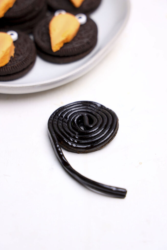 a roll of black licorice about to be cut up for feathers for the cookies.