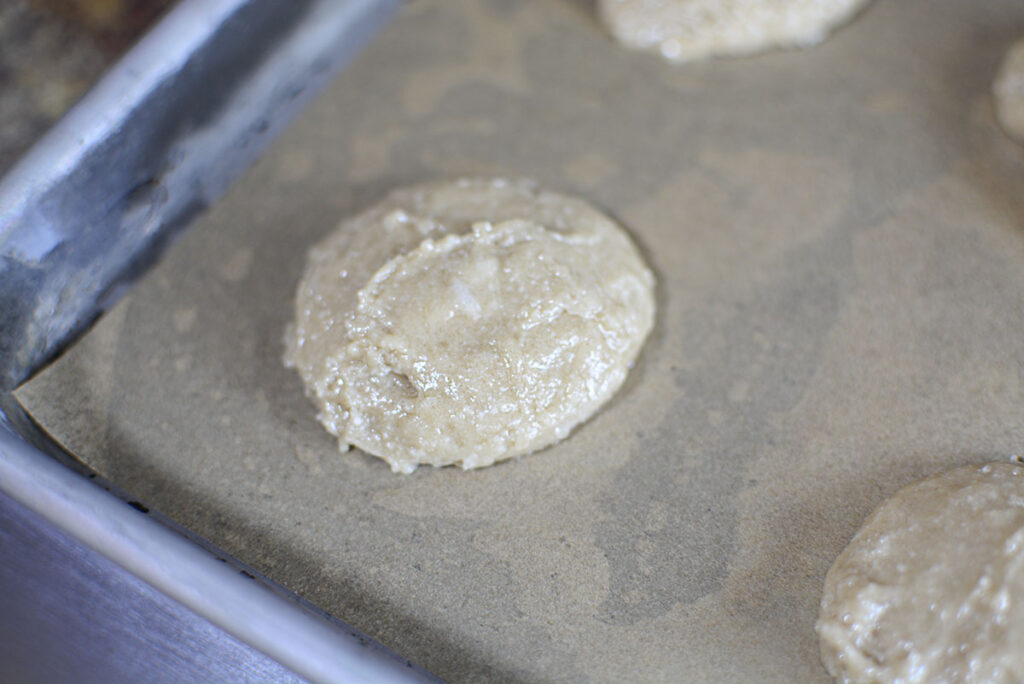 Raw cookie dough on parchment lined baking sheet.