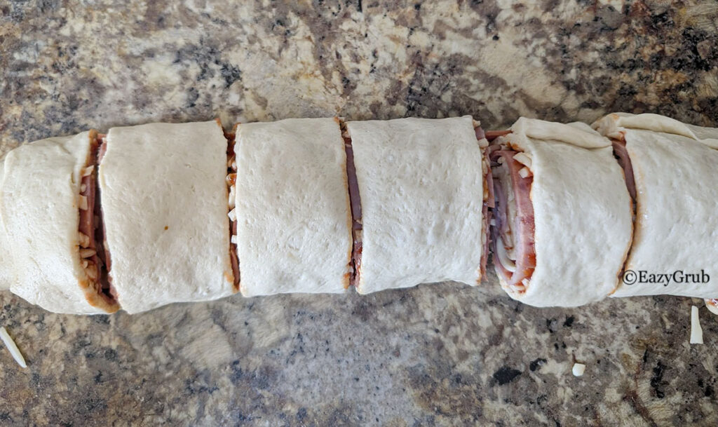 The rolled up dough sliced evenly into rolls.