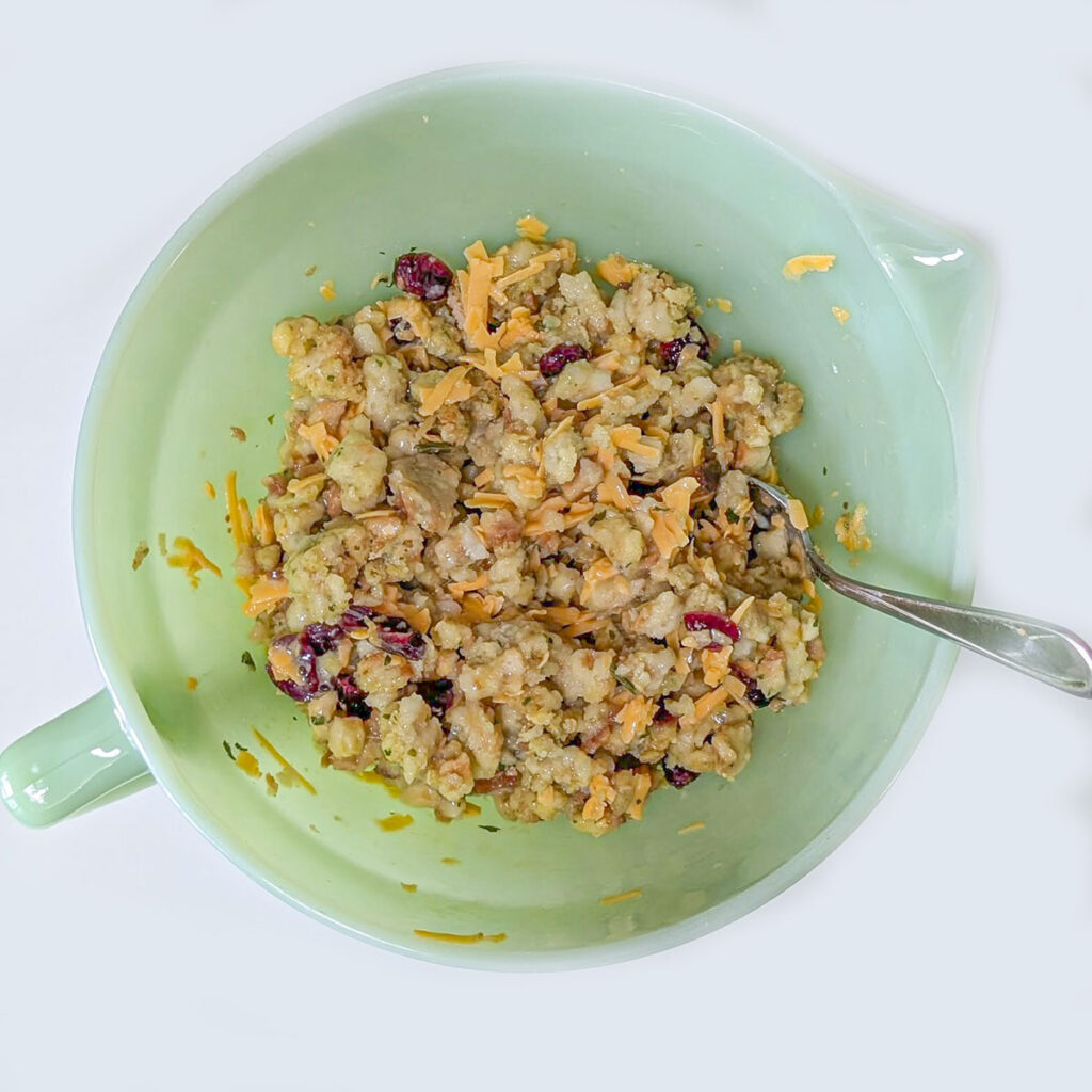 Mixed stuffing waffle batter combined with shredded cheese and cranberries in a bowl